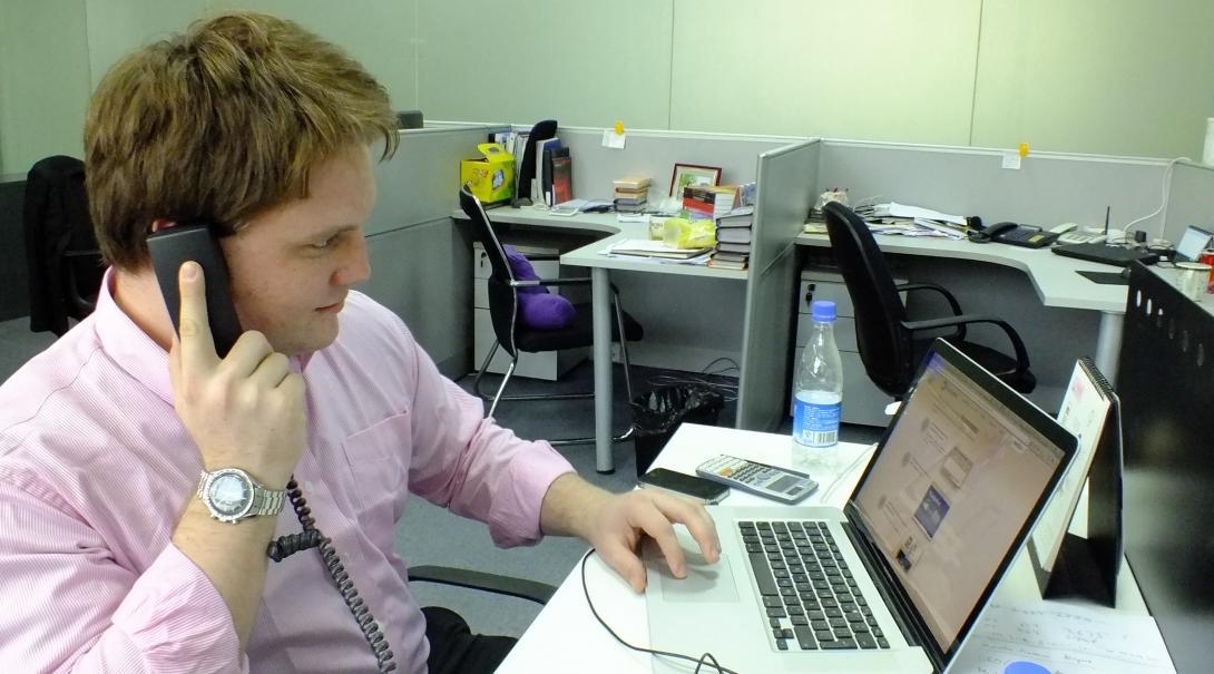 A legal intern consults with a client on the phone at his Law placement in China. A student doing a Law internship in China discusses a case with a client over the phone in Shanghai.